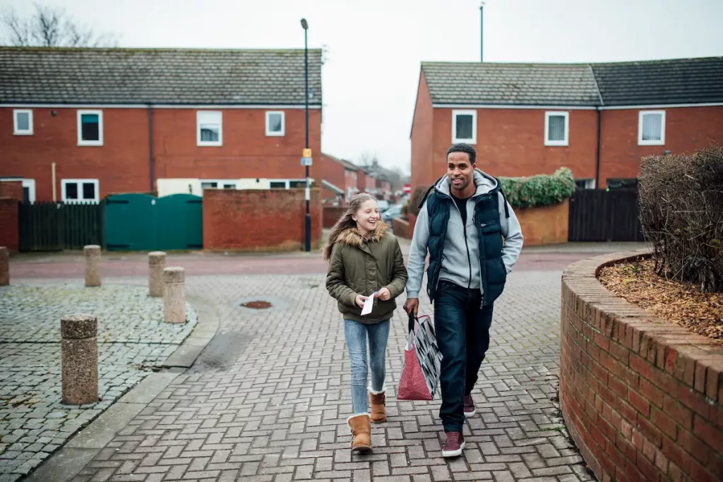 Single father walking his daughter to school in a suburb