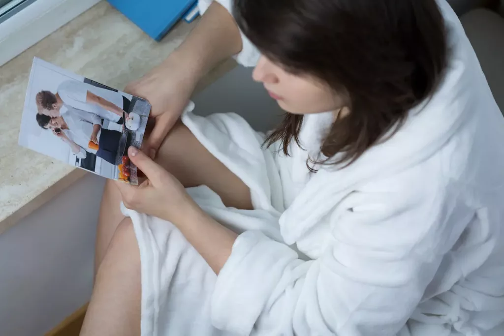 Female looking at picture of ex-husband wondering if he will miss her after divorce