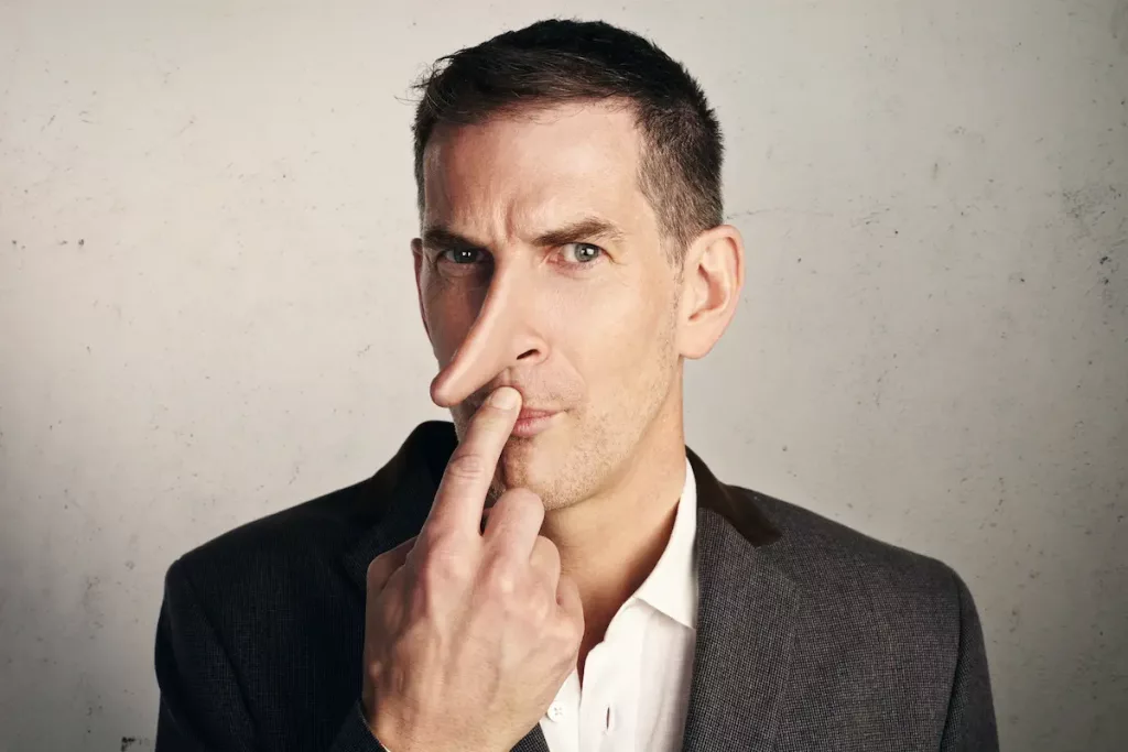 Man with long nose and finger on lips showing he is a liar