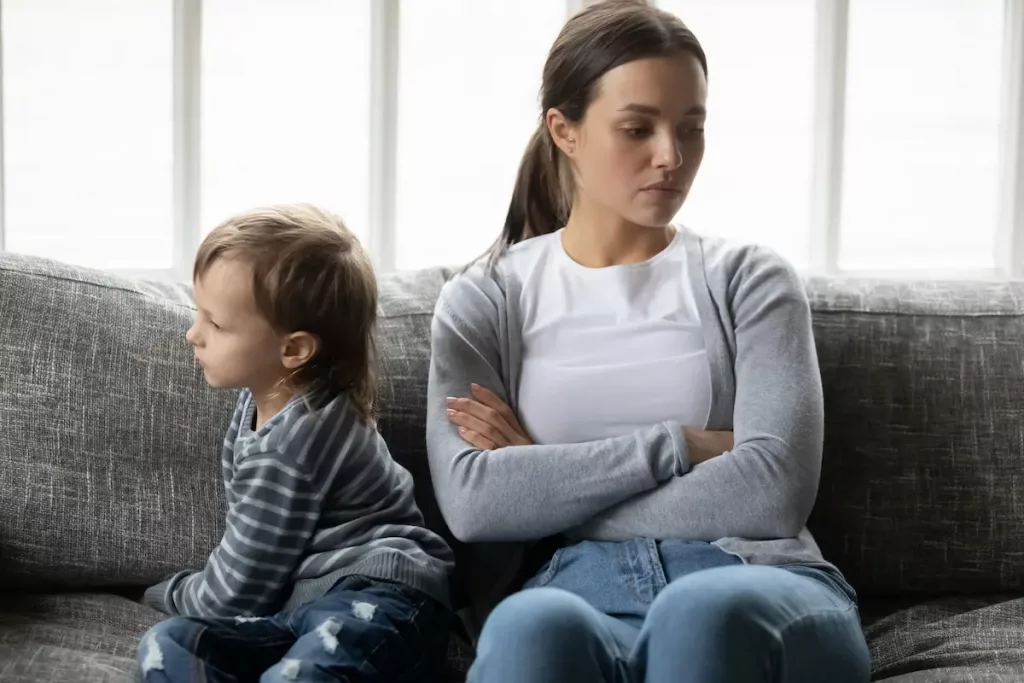 Young boy ignoring his mother who he is turned away from and only listens to his father