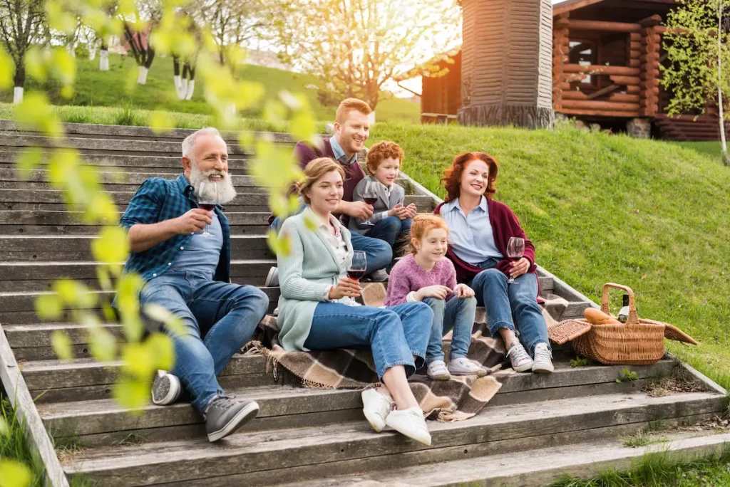 Happy family of children, parents and in-laws enjoying a picnic on stairs