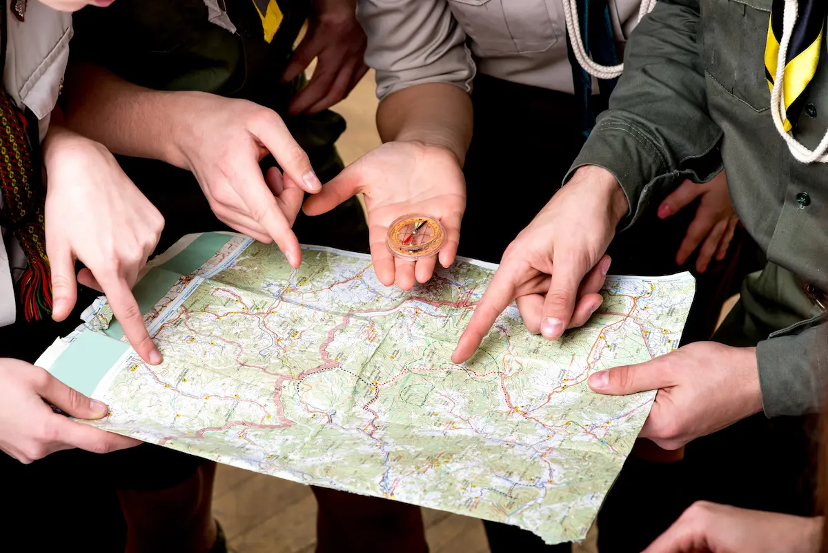 Close up of girl scouts looking at a map planning their trip