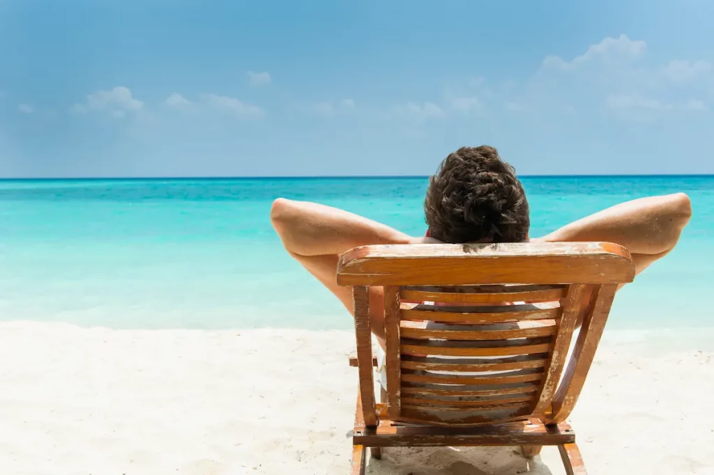 Husband on vacation alone relaxing on the beach in the sun