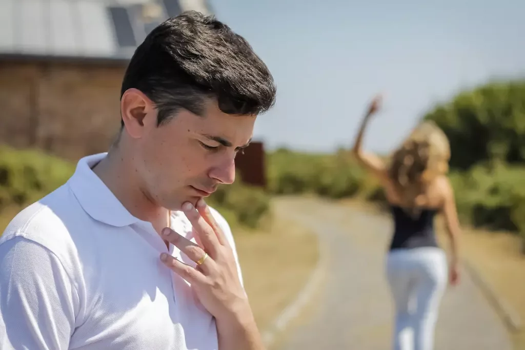 Confused husband stands thinking while wife walks off in background without him