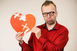 Man holding broken heart picture with a sad face after wife left him