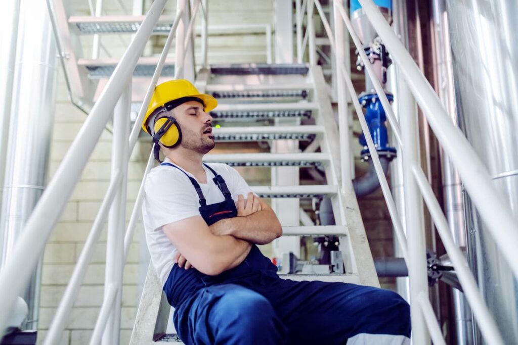 Shift worker at factory sleeping on stairs