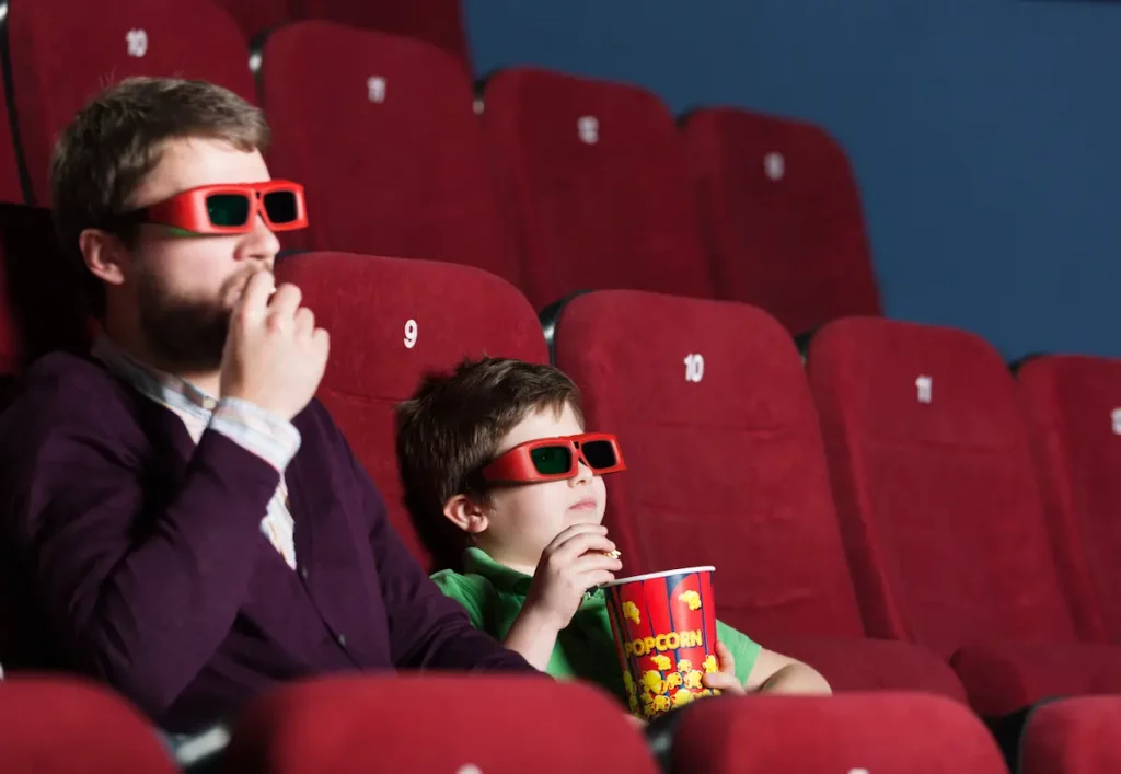 Father and son at the movie theatre who love watching movies about fathers