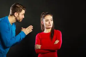 Angry wife looking the other direction from pleading husband next to her