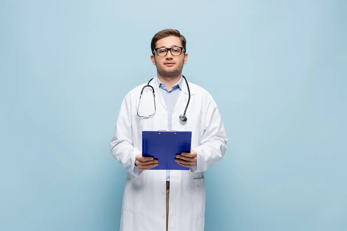 Doctor in white coat holding clipboard preparing for a vasectomy procedure
