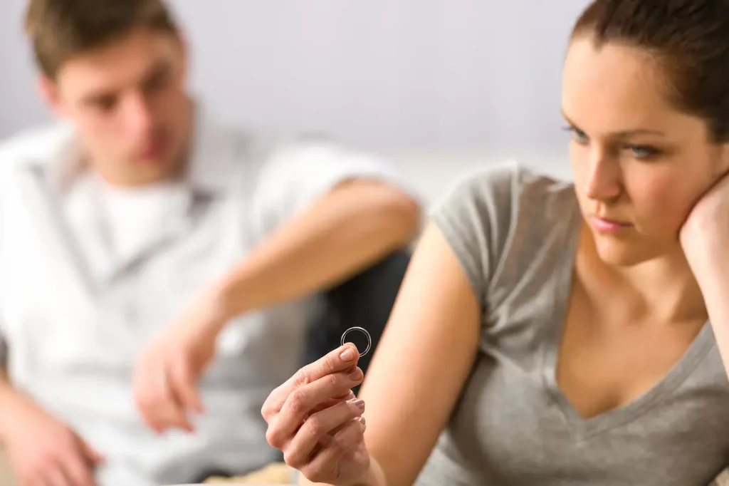 Wife holding wedding ring in front of her contemplating if she should leave husband
