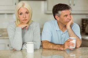 Wife upset while having coffee because husband Did Nothing For their Anniversary, and husband is looking off in the distance