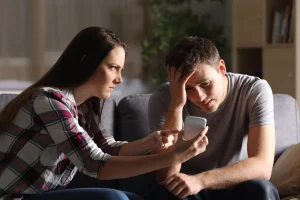 Wife showing husband pictures of potential woman to her husband, because she wants him to sleep with another woman