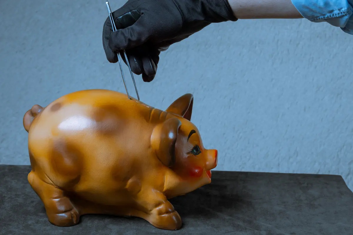 A parent using tweezers trying to take their kids money from a piggy bank