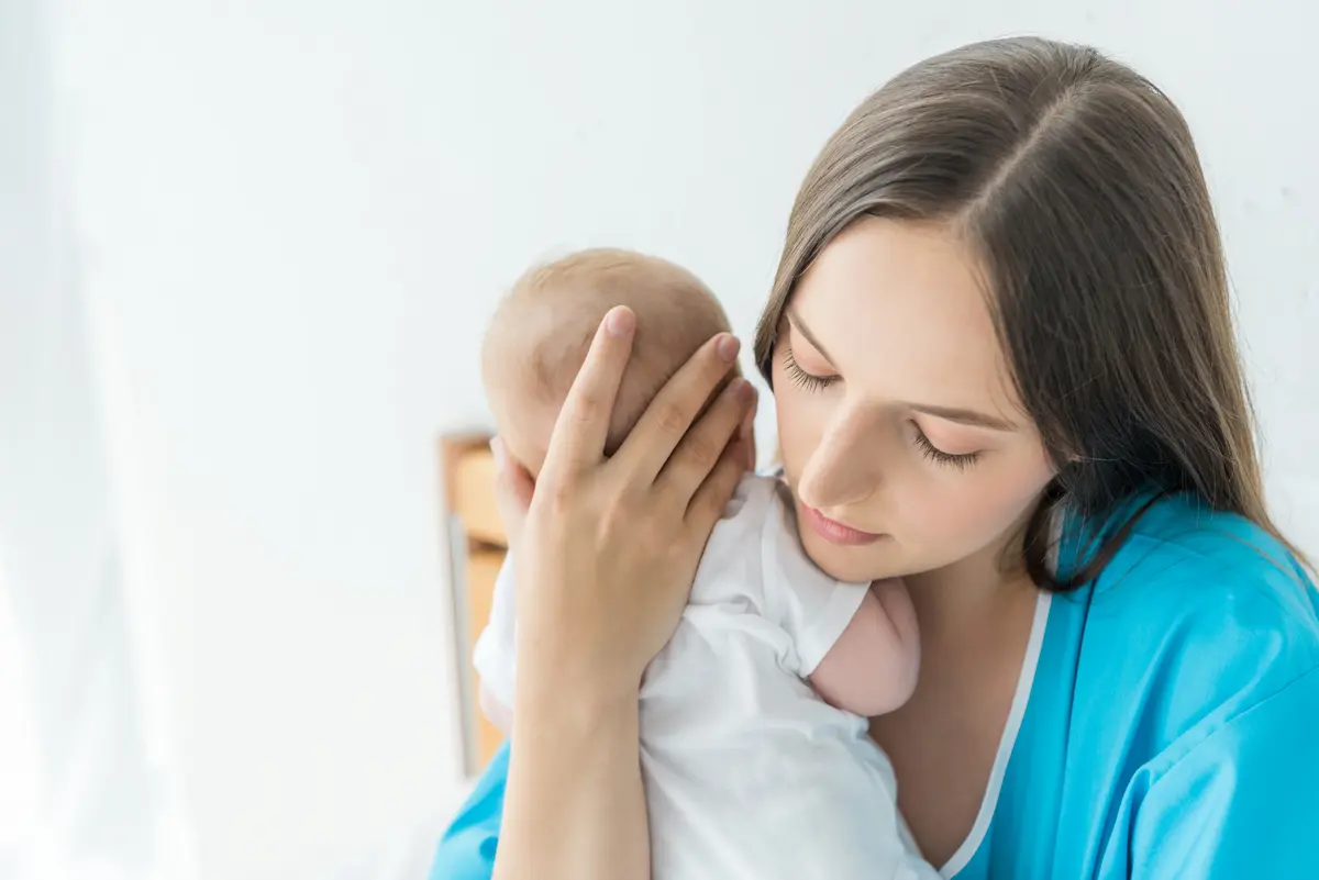 Mother holding new baby wanting to protect them from in-laws