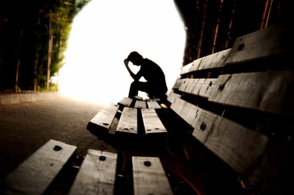 Man sitting on bench dealing with difficult decision on how to remove his dad from his life
