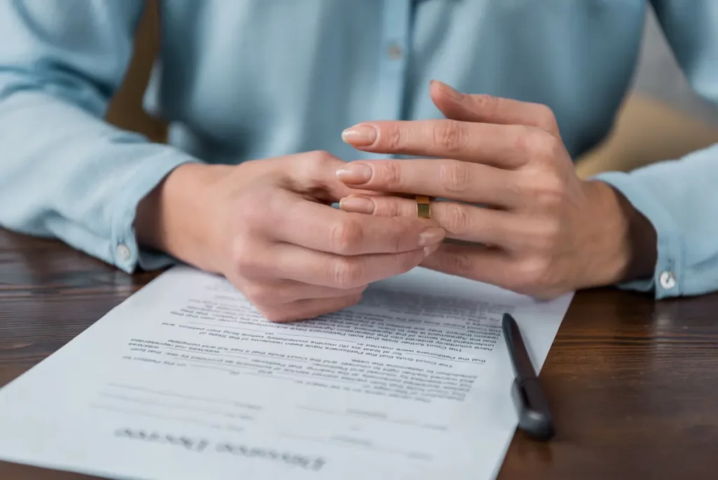 a "mrs." woman taking off wedding ring after divorce