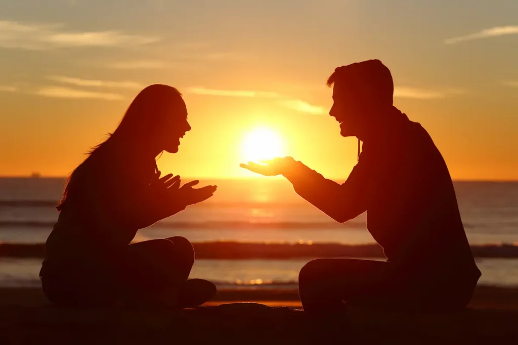 Couple on beach at sunset falling in love and laughing