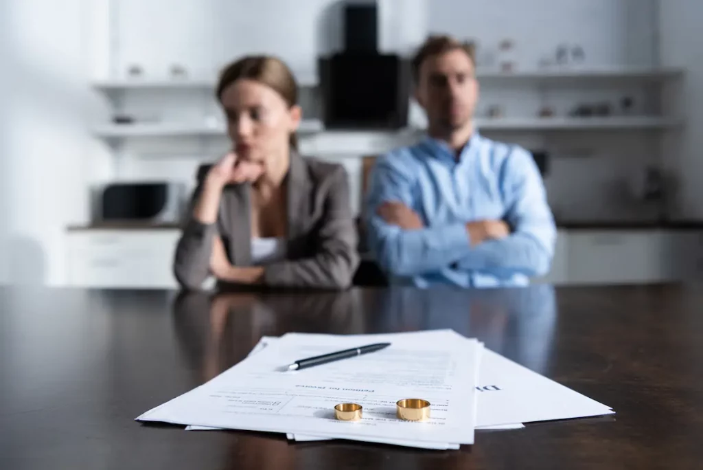 woman signing divorce paper work with narcissist husband
