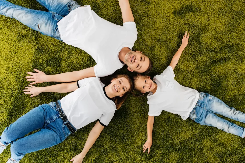 family wearing the same outfits laying on grass symbolizing family tendency