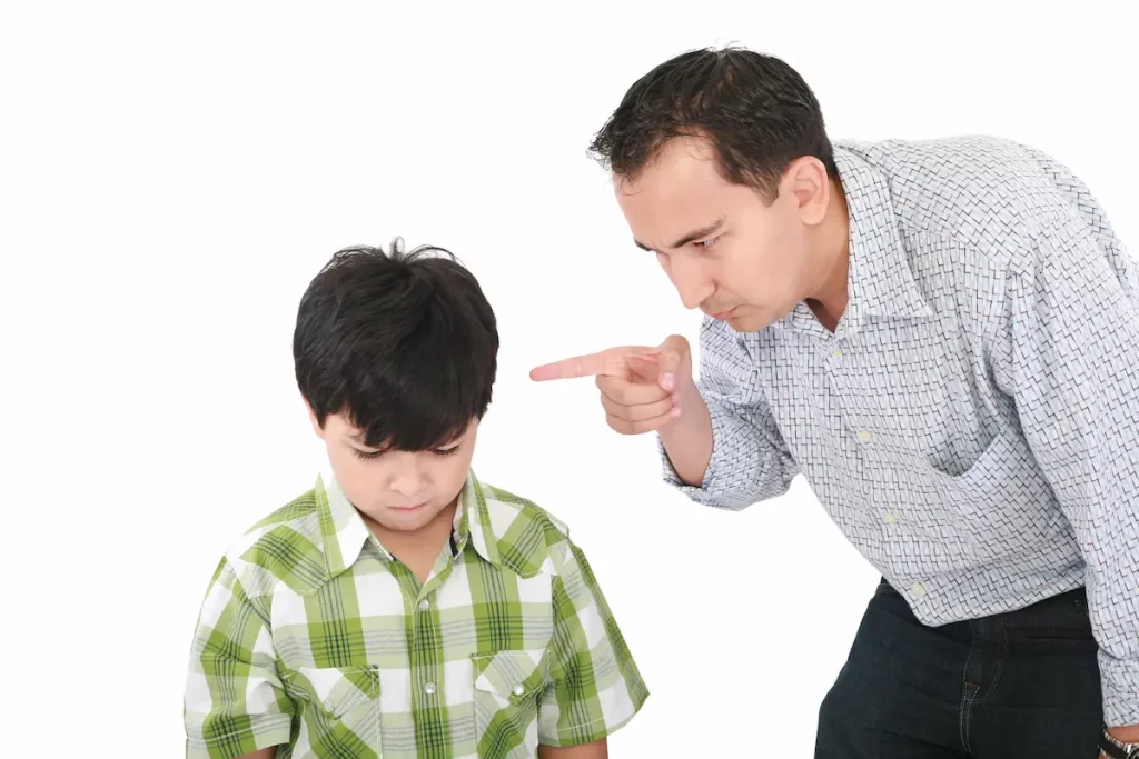 Authoritarian Parenting Example of father pointing finger at sad child