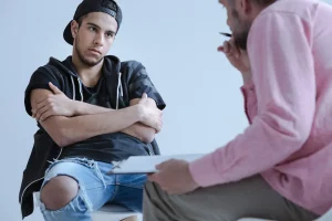Frustrated teenager sitting with therapist