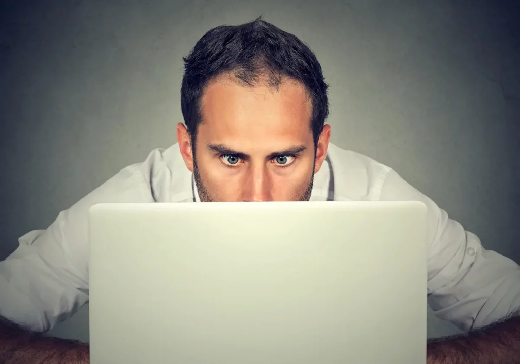 man on computer watching adult content secretly hiding from wife