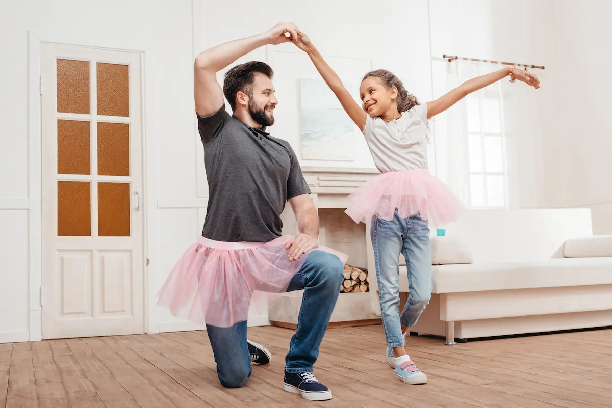 Father and daughter practicing ballerina dance in living room