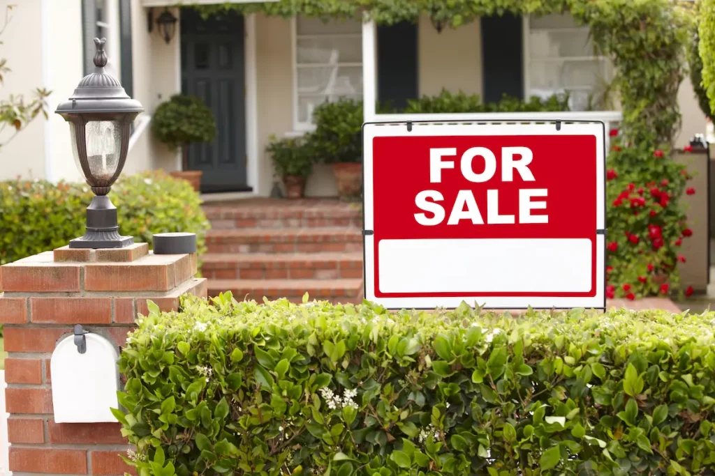 father selling his house with for sale sign out front