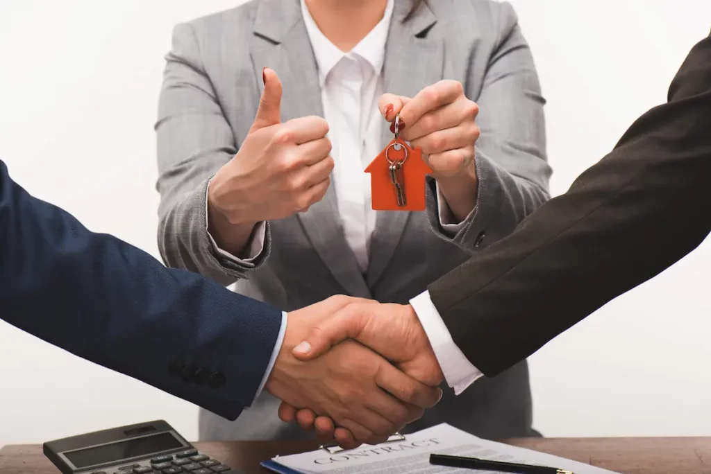 father selling his property to son with real estate agent in background