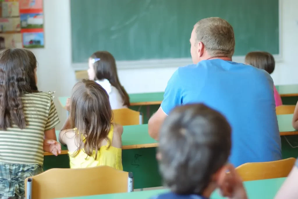 Helicopter parent sitting with child in class