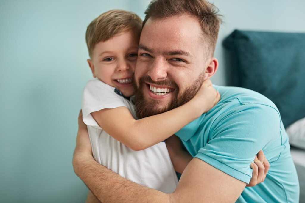 Close up of father cuddling his son