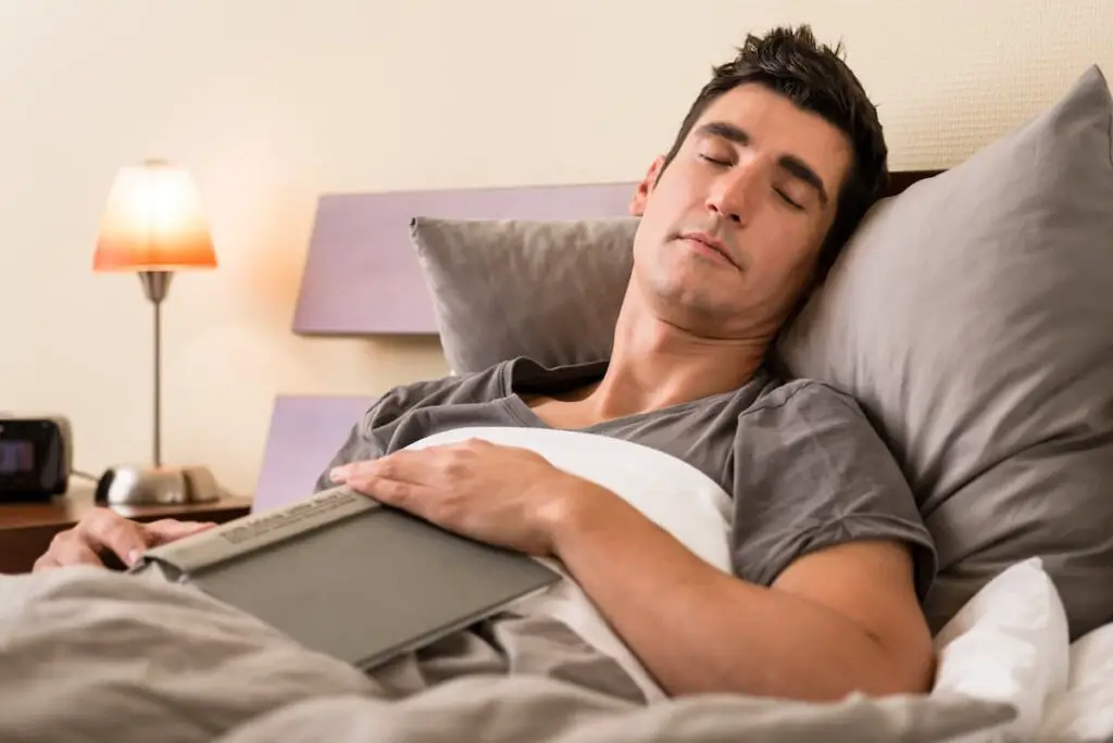 Man in bed falling asleep instantly while reading