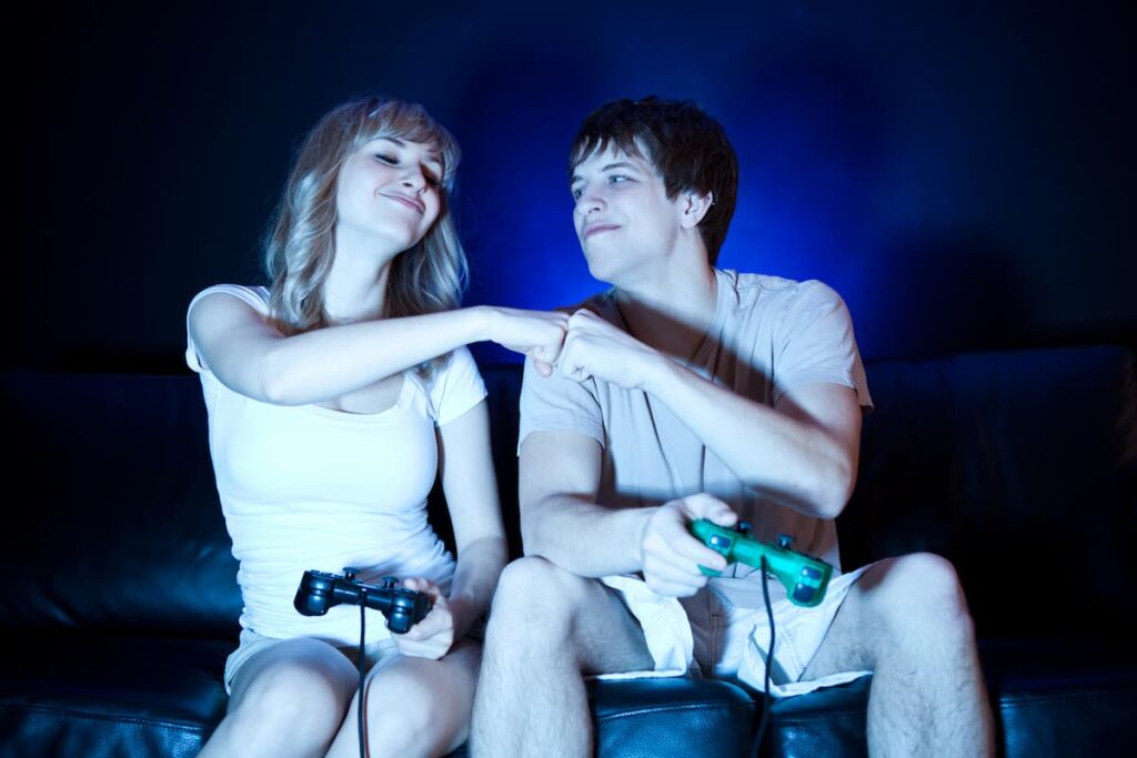 girlfriend and boyfriend playing call of duty video game on couch