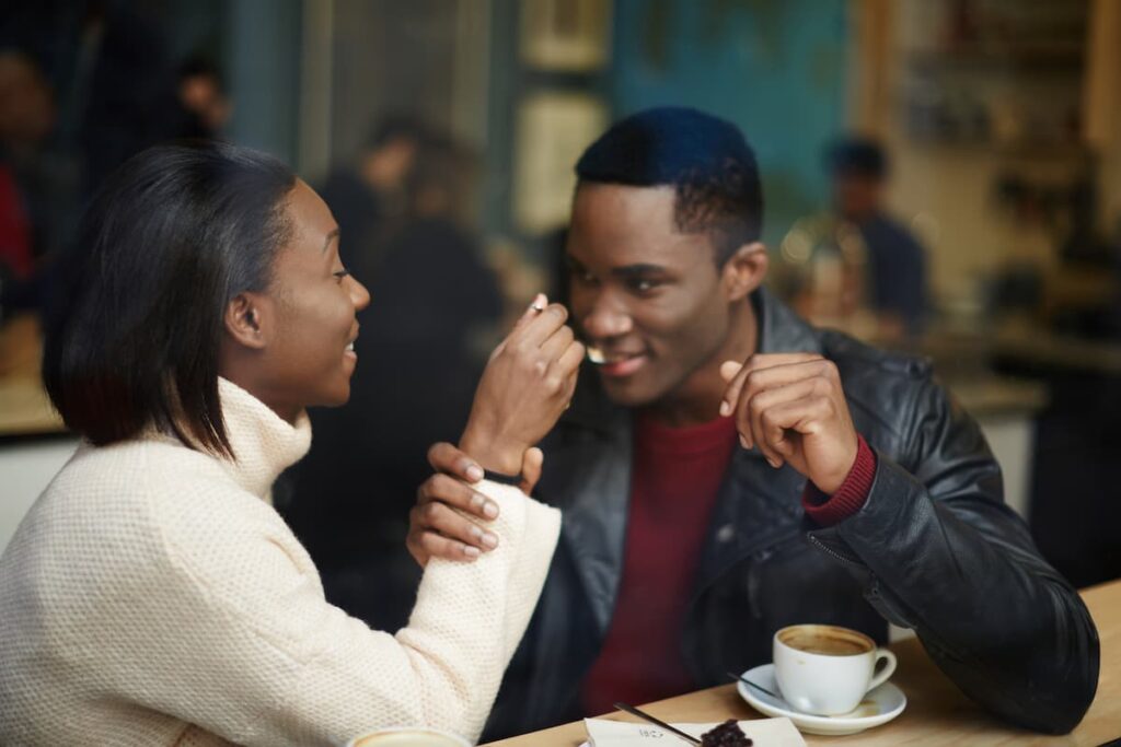 Girlfriend and boyfriend sharing drink at cafe symbolizing friendship and love