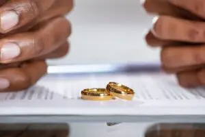 divorce symbolized by two wedding rings on top of paperwork